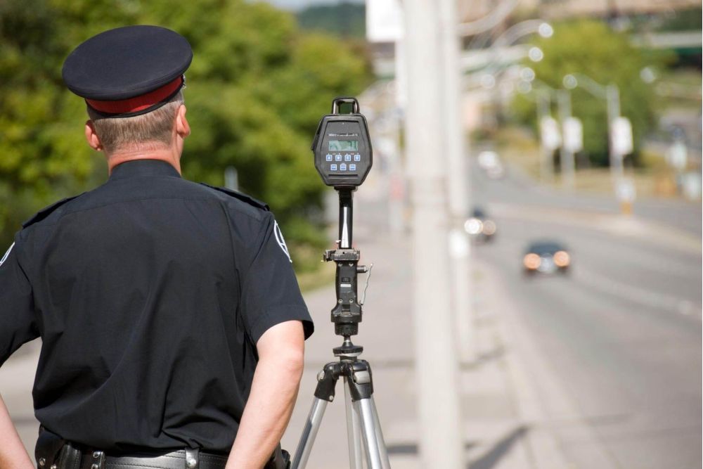 a police officer standing next to a speed meter