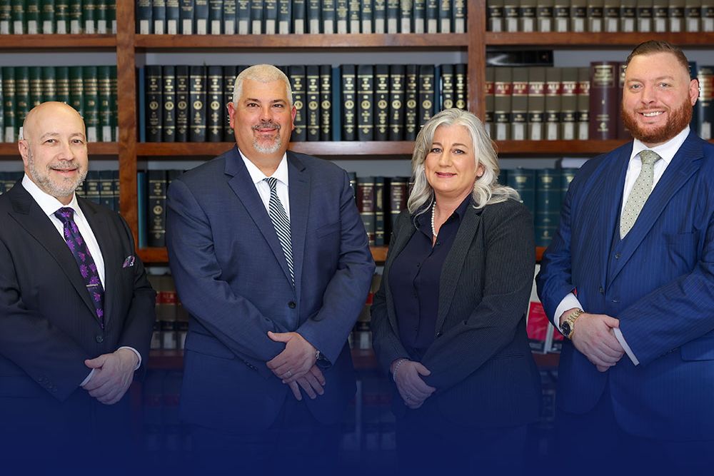 Randall, McClenney, Daniels & Dunn in formal attire standing in a library with law bookshelves.