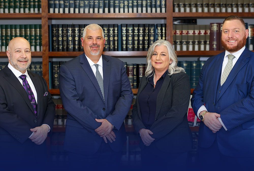 Randall, McClenney, Daniels & Dunn in formal attire standing in a library with law bookshelves.