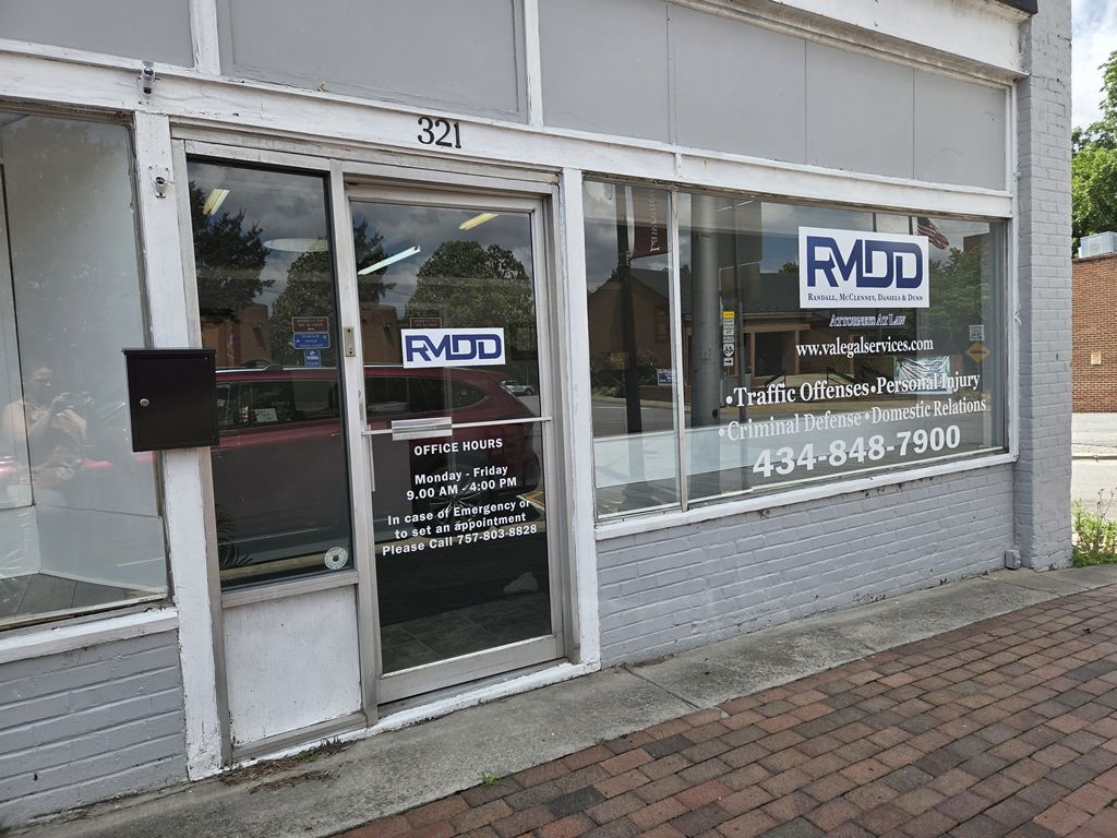 Law office storefront with RMDD logo, offering legal services like personal injury and criminal defense. Office hours displayed.