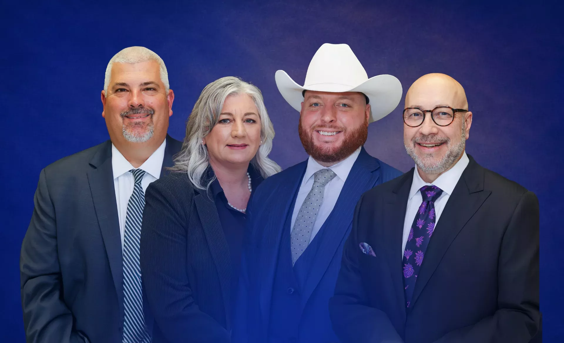 Four professionals in business attire, with one wearing a cowboy hat, standing against a blue background.