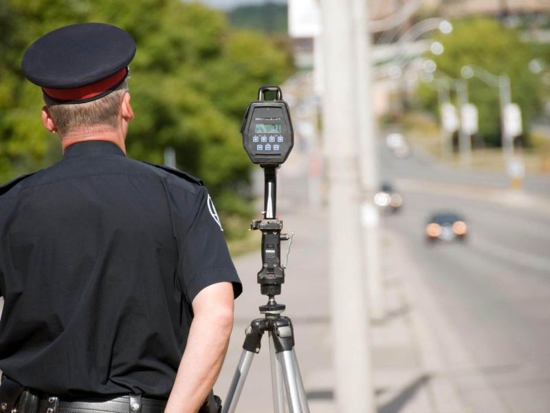 a police officer standing next to a speed meter