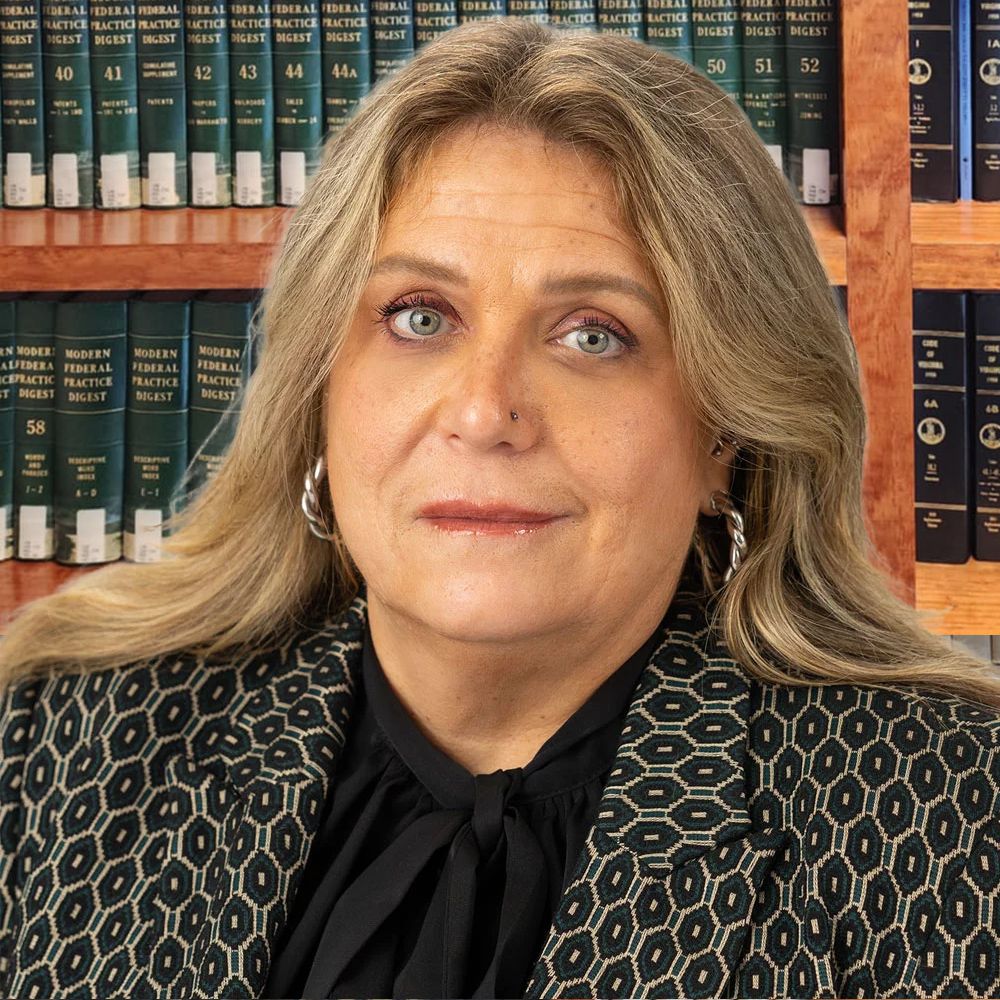 Professional woman in library with legal books in the background.