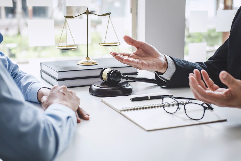 image of lawyers hands in motion explaining concepts to a client sitting across the desk from them