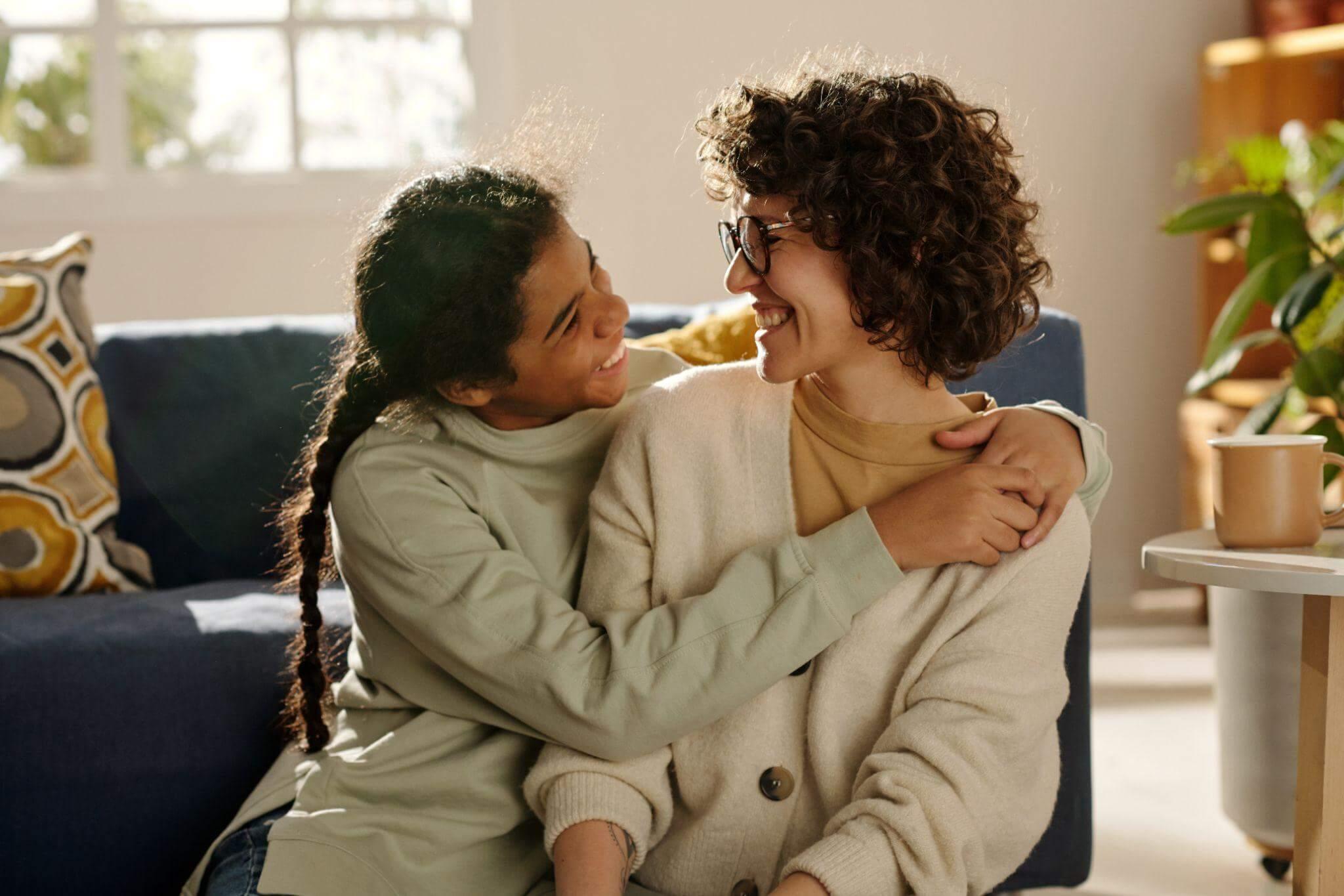 a couple of women sitting on top of a blue couch