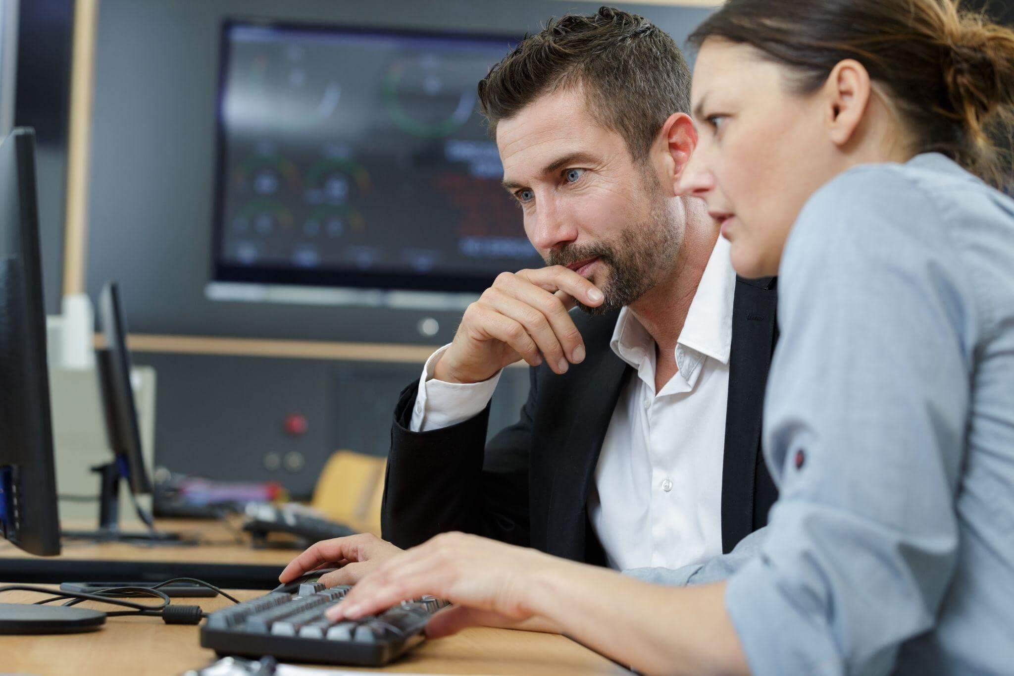 a man and a woman sitting at a computer