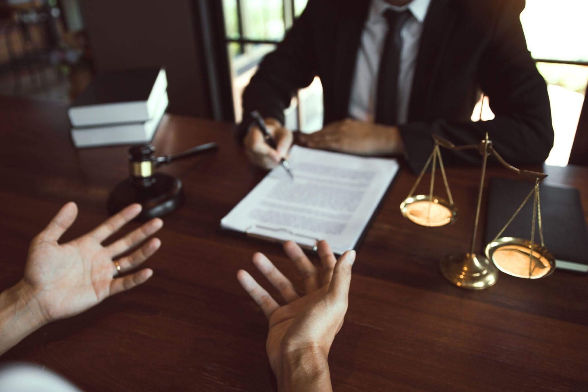 two people sitting at a table with a pen and paper