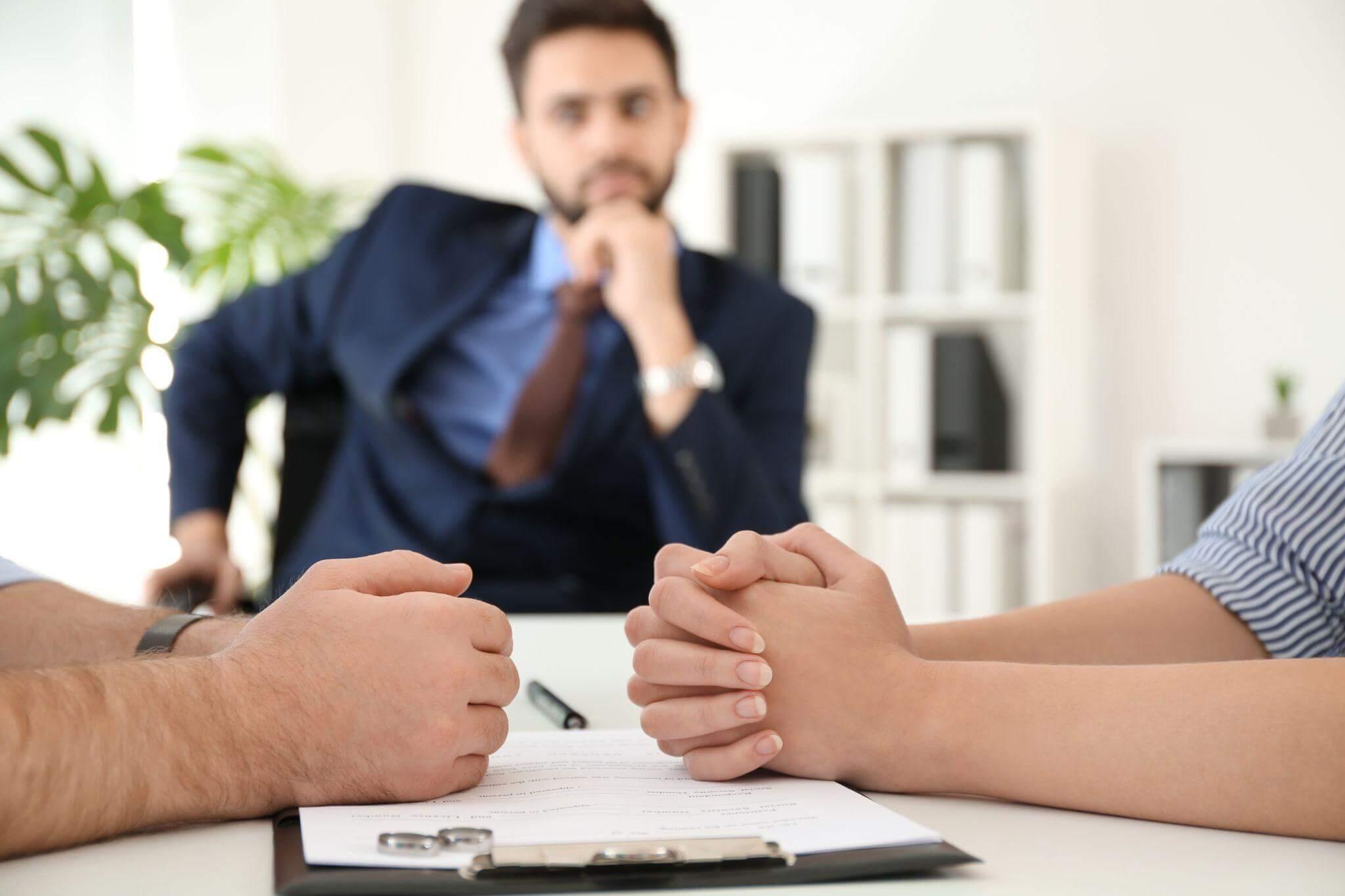 two people sitting at a table with a pen and paper